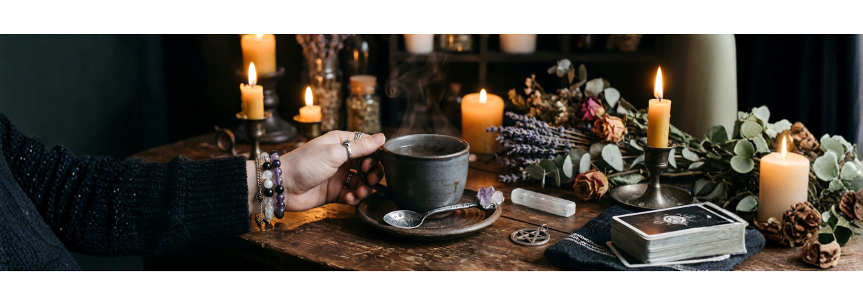 Spirituelt ritual med krystalarmb�nd, Gemstone Witch Spoon og en kop te omgivet af levende lys og t�rrede lavendler.