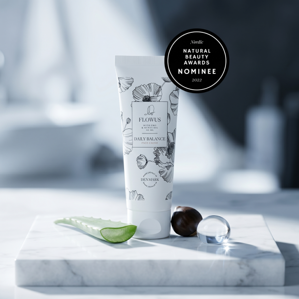 Flowus CBD ansigtscreme pr�senteret p� hvidt marmor omgivet af en frisk aloevera-blomst og en eksotisk kukui-n�d.