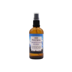 Opretst�ende Ancient Wisdom Room Spray Mountain Flora. En ravfarvet 100 ml glasflaske med sort spraypumpe og en etiket prydet med et lilla og bl�t bjergmotiv.