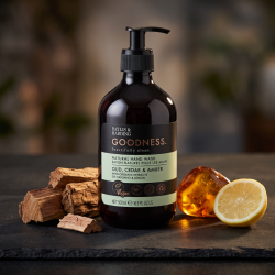 N�rbillede af den m�rke Baylis & Harding pumpeflaske, st�ende skarpt p� en rustik, m�rk stenplade. Et par rustikke stykker cedertr�, en bl�d, ravgylden ravsten og et frisk, halvt citron-slice ligger elegant placeret foran flasken i et varmt, d�mpet lys.