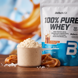 Et krystalklart makrobillede af en perfekt skefuld l�kkert, luftigt, beige-farvet proteinpulver (Salted Caramel) placeret sirligt p� en m�rk tr�overflade ved siden af den realistiske, hvide og lysebl� BioTechUSA Pure Whey pose (helt uden pipetter, dr�bet�llere eller vanddr�ber). Den bl�dt sl�rede baggrund kombinerer varme, flydende karamel-nuancer og lysebl� atletiske refleksioner, som diskret og elegant repr�senterer den uimodst�elige smag og den h�je sportsern�rings-kvalitet. Lyset er dynamisk, lyst og indbydende, hvilket fremh�ver total f�devarekvalitet og renhed. Knivskarpt fokus.