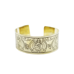 Et bredt, gyldent messingarmb�nd, formet som en cuff, med detaljerede, sorte indgraveringer af de fem tibetanske buddhaer og buddhistiske symboler.