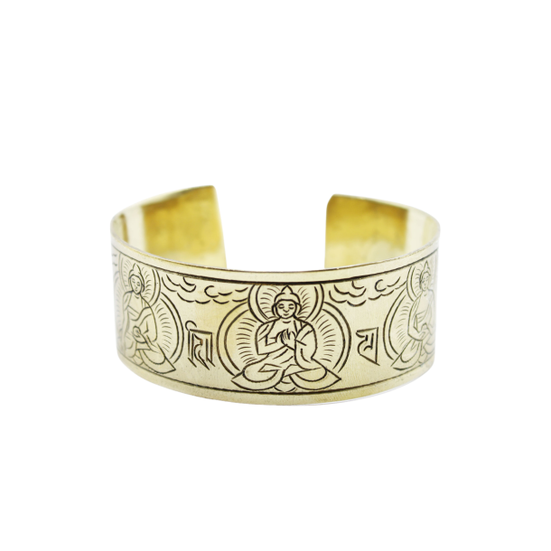 Et bredt, gyldent messingarmb�nd, formet som en cuff, med detaljerede, sorte indgraveringer af de fem tibetanske buddhaer og buddhistiske symboler.