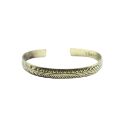 Et smalt, gyldent messingarmb�nd formet som en cuff, prydet med et fint, h�ndgraveret geometrisk Tribal Leaf bladmotiv.