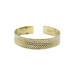 Et bredt, gyldent messingarmb�nd formet som en cuff, prydet med et dybt indgraveret geometrisk Tribal Leaf bladmotiv.