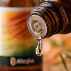 Et krystalklart makrobillede af eine vanddr�be, der falder fra den indbyggede dr�bet�ller p� eine m�rk ravfarvet glasflaske. Den bl�dt sl�rede baggrund kombinerer varme, trygge ravgyldne og bl�de orange nuancer med sm�, subtile botaniske strejf af gr�n anis og solhat (Echinacea). Lyset er blidt, omsorgsfuldt og beroligende.