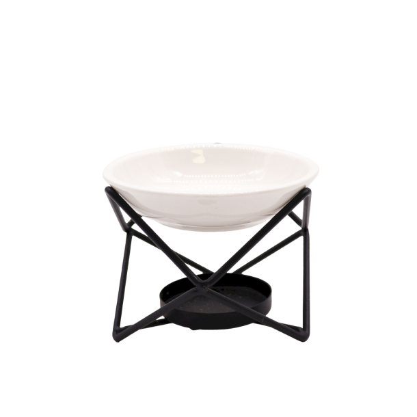 En moderne geometrisk duftlampe kaldet Hex Stand, best�ende af en krydsende sort metalramme med en hvid glaseret keramiksk�l p� toppen.