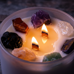 Seven Chakra krystallyset set ovenfra i glasset. Lyset har to tr�v�ger og er dekoreret med syv store, r� �delsten i forskellige farver neds�nket i hvid sojavoks.