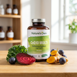 Nature's Own CoQ10 MULTI d�se p� bambustr� omgivet af friske r�varer som k�l, r�dbede og gurkemeje.