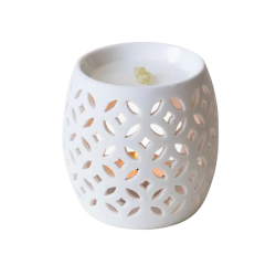 Firefly duftlampe i hvidt porcel�n med udsk�rne huller. Vist i dagslys med et par stykker gr�nlig harpiks liggende i den �verste sk�l.