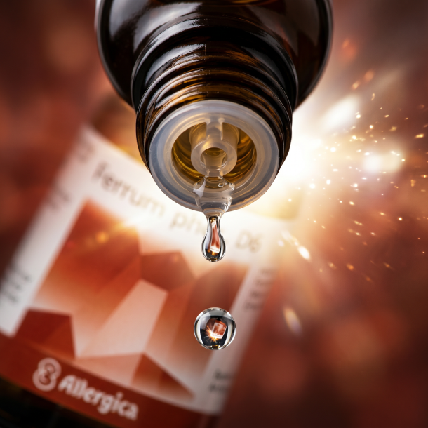 Et krystalklart makrobillede af en vanddr�be, der falder fra den indbyggede dr�bet�ller p� en m�rk ravfarvet glasflaske. Den bl�dt sl�rede baggrund kombinerer varme, rust-r�de og jordbundne jernfarver med lysende, str�lende glimt af ren hvid/gylden energi (fosfor). Lyset er ekstremt klart, dynamisk, og udstr�ler absolut indre vitalitet, kropslig parathed og hom�opatisk pr�cision.