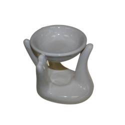 En smuk hvid keramisk duftlampe formet som to hj�lpende h�nder, der n�nsomt b�rer en lille rund sk�l til vand og �teriske olier.