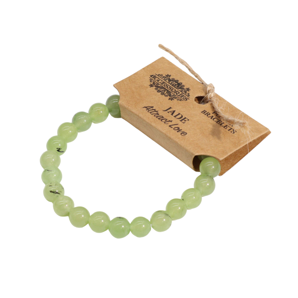 Jade Power Armb�nd med lysegr�nne natursten-perler p� 8mm. Armb�ndet ligger fladt med et brunt papm�rke fastgjort med jutesnor, hvorp� der st�r 'AW ACCESSORIES POWER BRACELETS', 'JADE' og 'Attract Love'.