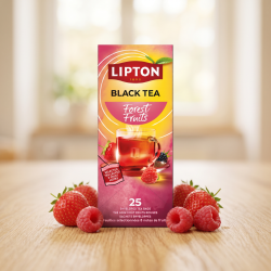 N�rbillede af den h�jformatede, pink og gule Lipton te�ske st�ende skarpt p� en lys overflade af ahorntr�. Friske, dugv�de jordb�r og hindb�r ligger dekorativt spredt foran i bl�dt lys.