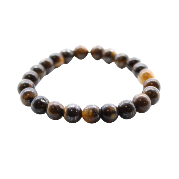 N�rbillede af Tiger�je Power Armb�ndet set fra en skr� vinkel. Man ser de polerede, gyldenbrune krystalperler og m�rket, der er fastgjort med en jutesnor. Armb�ndet er one-size og elastisk.