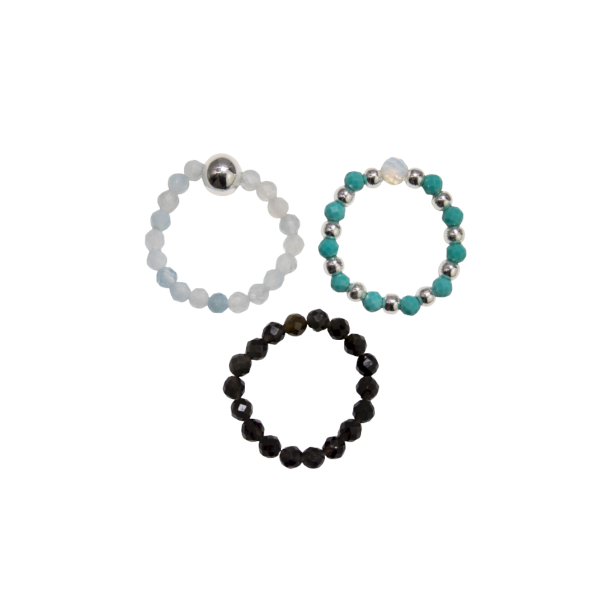 Tre l�se 'Endless Ocean' elastikringe lagt samlet. Ringene best�r af lysebl� akvamarin, m�rketurkis, glat sort obsidian og sm�, blanke fors�lvede perler.