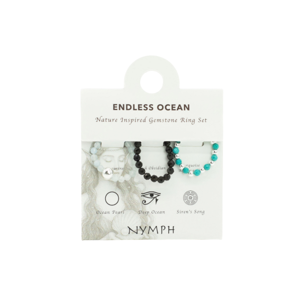 Nymph 'Endless Ocean' �delstensringe s�t pr�senteret p� et lyst displaykort. Kortet viser tre elastiske krystalringe med akvamarin, obsidian og turkis ud for deres unikke navne og symboler: Ocean Pearl, Deep Ocean og Siren's Song.