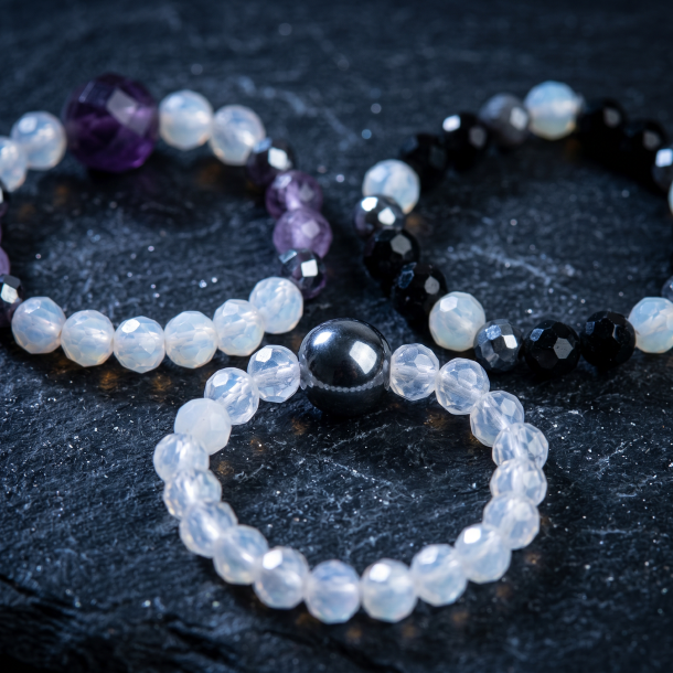 Tre smukke elastiske krystalringe med m�lkehvid m�nesten, sort obsidian, violet ametyst og sm� fors�lvede perler.