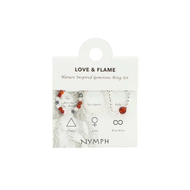 Nymph 'Love & Flame' �delstensringe s�t pr�senteret p� et lyst displaykort. Kortet viser tre elastiske krystalringe med rosakvarts og rubin ud for deres unikke navne og symboler: Flame, Love og Evermore.