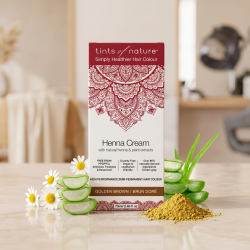 Tints of Nature h�rfarve-�ske pr�senteret p� varmt marmor, ledsaget af friske aloe vera-stykker og kamilleblomster i et eksklusivt, �kologisk salon-milj�.