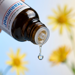 Et krystalklart makrobillede af en vanddr�be, der falder fra den indbyggede dr�bet�ller p� en 1:1 realistisk m�rk ravfarvet glasflaske. Den bl�dt sl�rede baggrund kombinerer friske, lysebl� nuancer med blide, botaniske gule glimt (Arnica montana/Morgenfrue). Lyset er ekstremt klart, genopbyggende, og udstr�ler absolut forl�sning af fysisk overbelastning, restitution og hom�opatisk pr�cision.