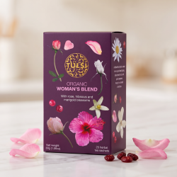 N�rbillede af den smukke lilla Tulsi te�ske st�ende p� et lyst marmorbord, elegant flankeret af friske, sarte rosenblade og et par t�rrede traneb�r i et bl�dt og roligt morgelys.