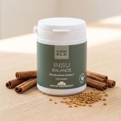N�rbillede af den hvide Natur-Drogeriet d�se med gr�n etiket. D�sen st�r skarpt p� et lyst tr�bord og er smukt og elegant omgivet af hele kanelst�nger og spredte, gyldne bukkehornsfr� i et krystalklart, naturligt lys.